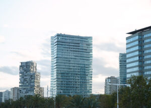 Modern glass and concrete city buildings minutes after sunset against clear white sky